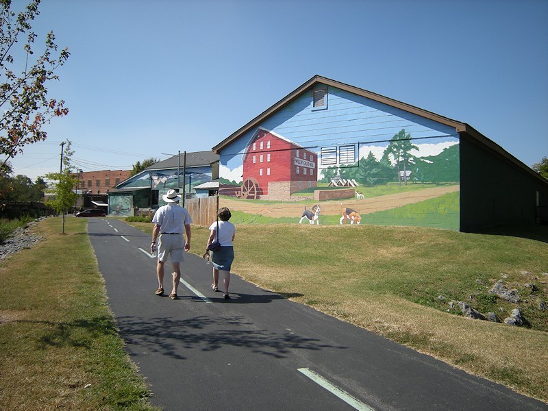 couple walking by Mural on the Greenway